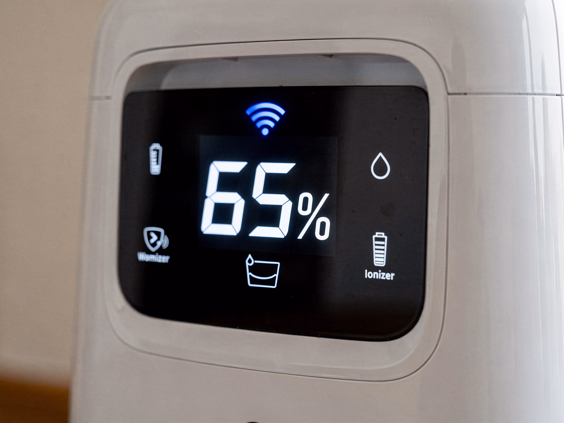Détail du panneau de contrôle tactile d'un déshumidificateur connecté affichant le taux d'humidité et l'icône Wi-Fi