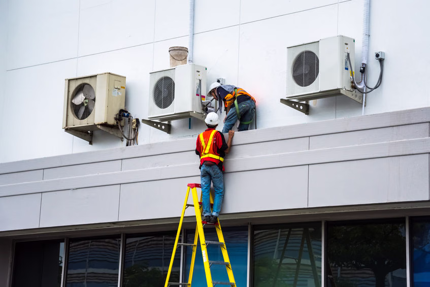 Technicien vérifiant les critères techniques d'un climatiseur